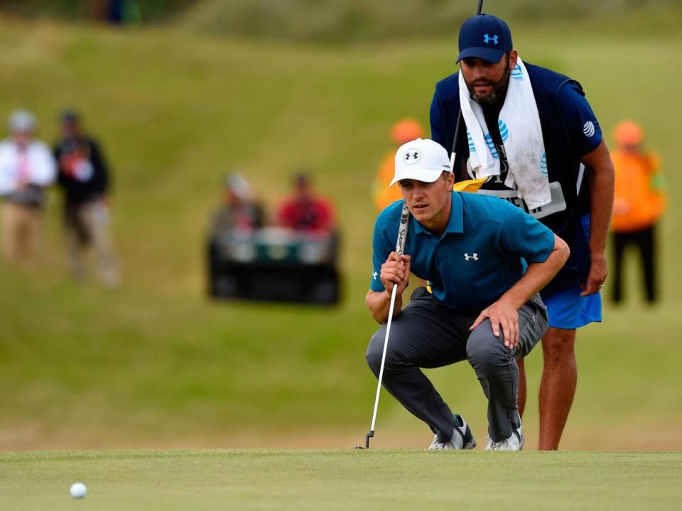 Greller looks on as Spieth weighs up his putt (Getty)