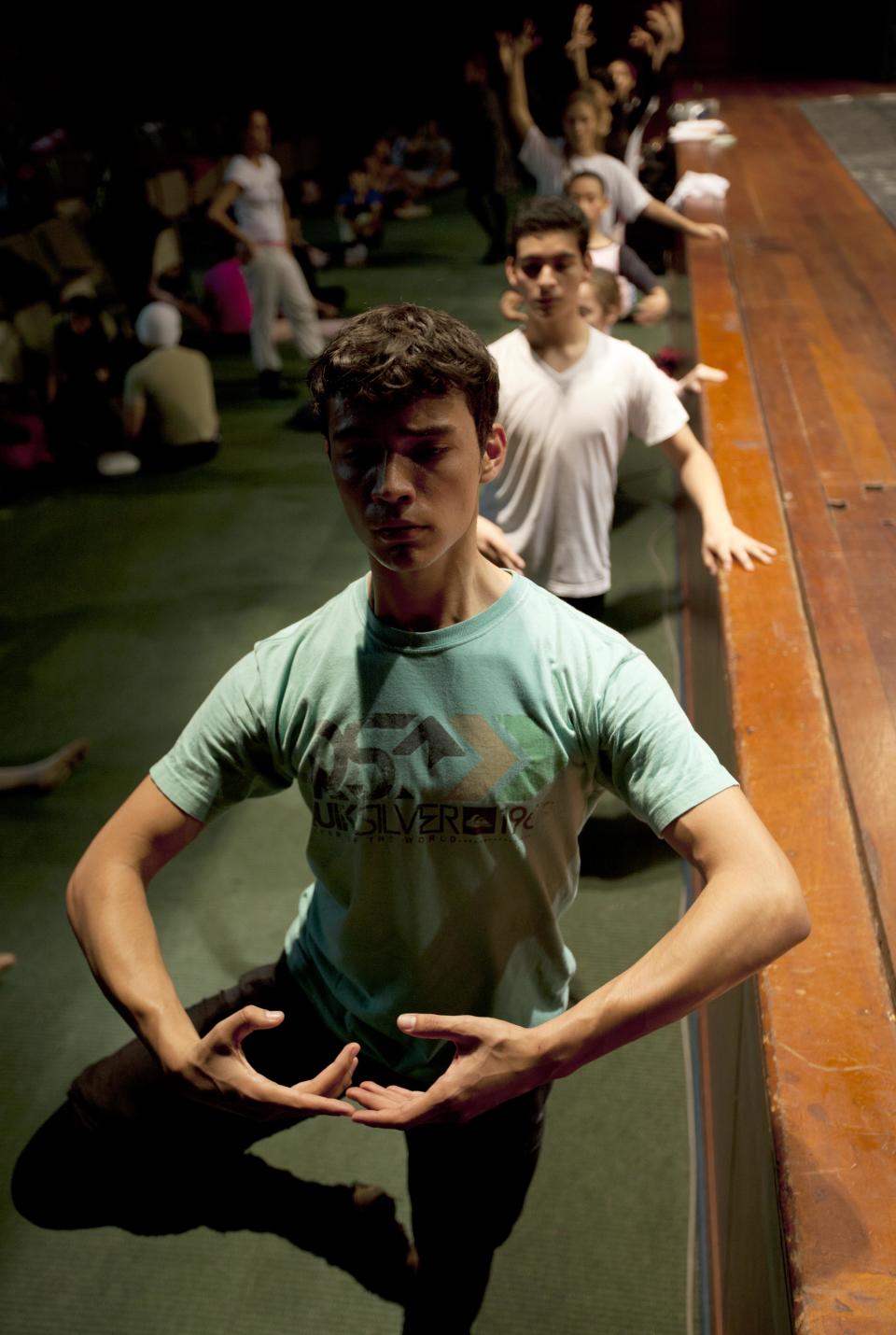 In this Sept. 3, 2012 photo, dancers practice for a competition between ballet schools below the stage inside the National Museum in Lima, Peru. Nearly 100 girls and boys from Colombia, Venezuela, Chile, France and Peru are submitting themselves to a week-long competition hoping to win medals from Peru's national ballet school _ and perhaps a grant to study in Miami. (AP Photo/Martin Mejia)