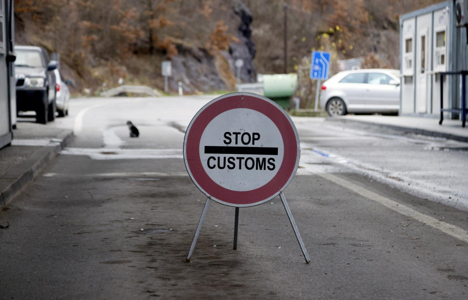 A traffic sign is seen at the closed border crossing of Jarinje, along the Kosovo-Serbia border, Kosovo, Sunday, Dec. 11, 2022. Kosovo police and the local media on Sunday reported explosions, shooting and road blocks overnight in the north of the country, where the popoulation is mostly ethnic Serb, despite the postponement of the Dec. 18 municipal election the Serbs were opposed to. No injuries have been reported. (AP Photo/Marjan Vucetic)