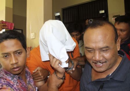 American Tommy Schaefer is escorted by police inside a police hospital to undergo medical checks in Denpasar on the Indonesian resort island of Bali August 15, 2014. REUTERS/Zul Edoardo