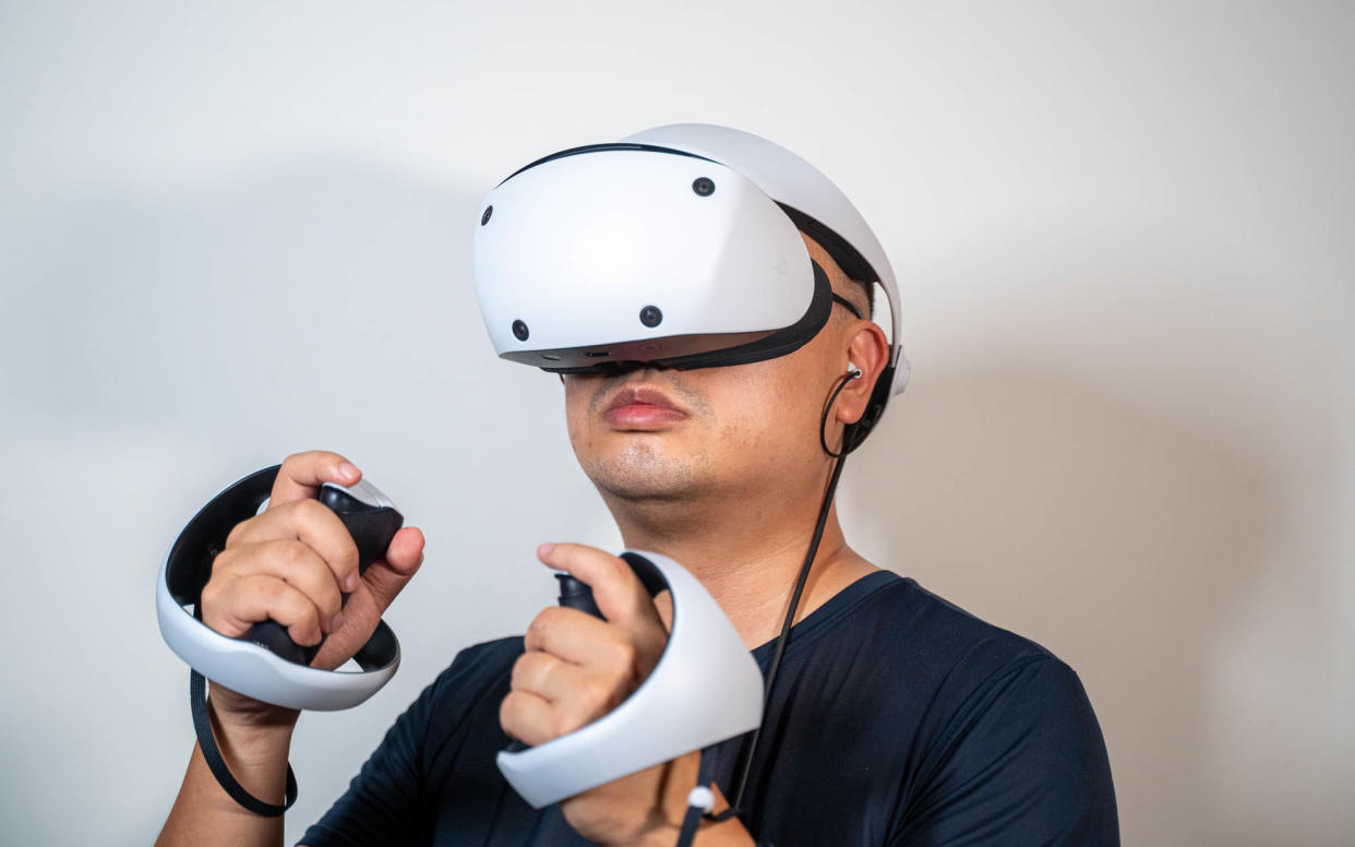 A man using the PlayStation VR2 to play games.