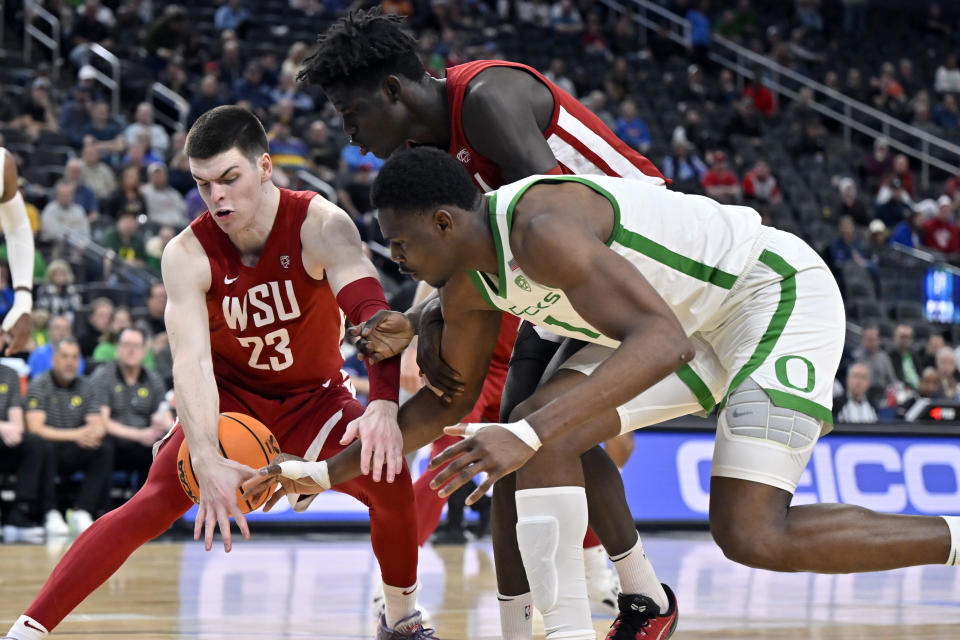 Washington State forward Andrej Jakimovski (23), forward Mouhamed Gueye, center, and Oregon center N'Faly Dante chase the ball during the second half of an NCAA college basketball game in the quarterfinals of the Pac-12 Tournament, Thursday, March 9, 2023, in Las Vegas. (AP Photo/David Becker)