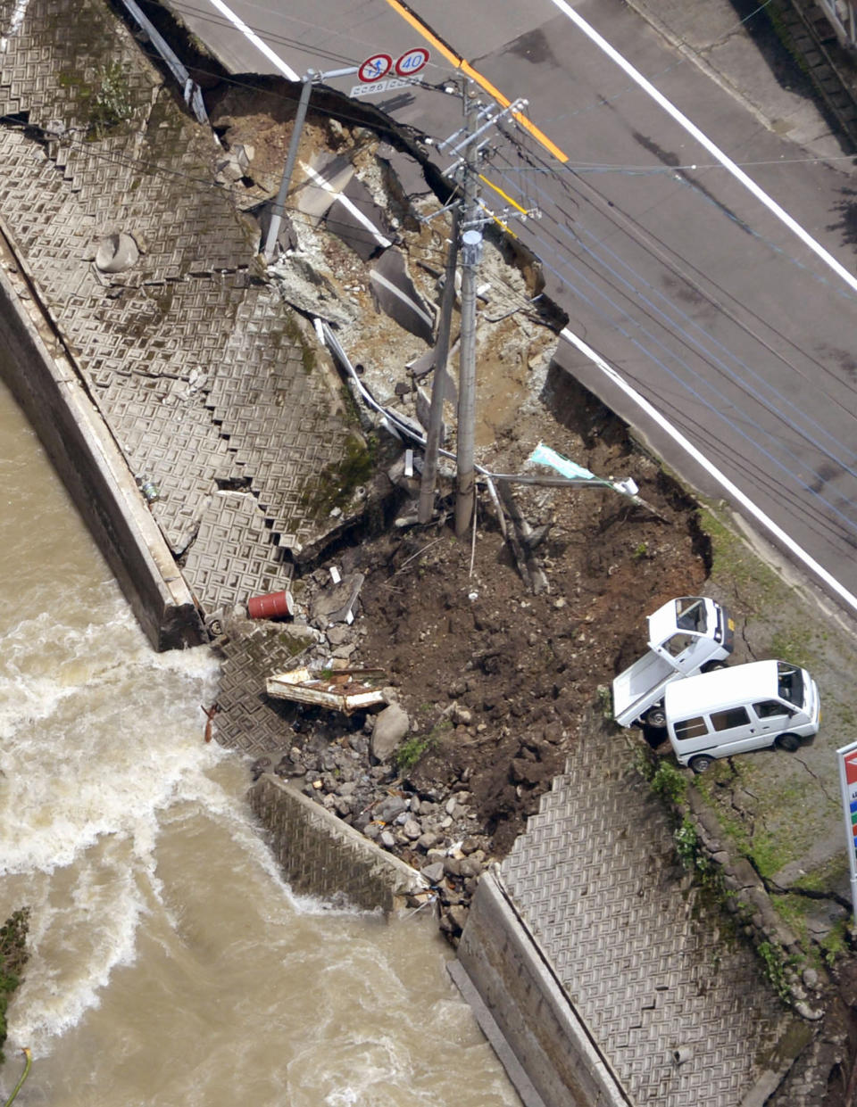 A road along a river is partially collapsed in Yame, Fukuoka Prefecture, Japan, Sunday, July 15, 2012. Heavy rain triggered flash floods and mudslides in southern Japan this week, killing over two dozens of people. (AP Photo/Kyodo News) JAPAN OUT, MANDATORY CREDIT, NO LICENSING IN JAPAN, CHINA, HONG KONG, SOUTH KOREA AND FRANCE