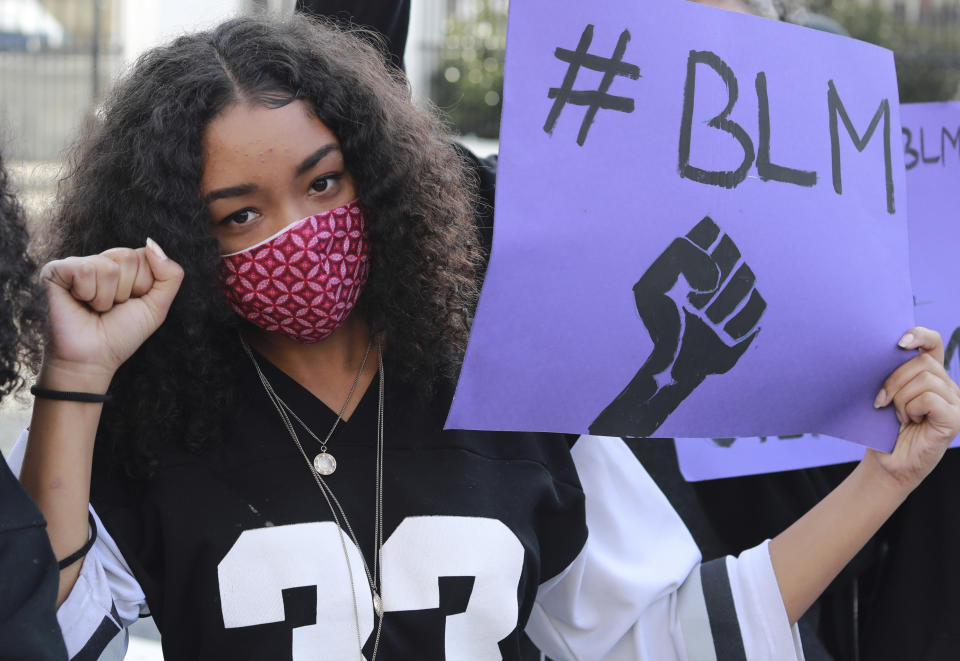 A demonstrator attends a protest under the slogan Black Lives Matter, (BLM) outside parliament in Cape Town, South Africa, Wednesday June 3, 2020, over the death of George Floyd in the USA. Floyd died in police custody on Memorial Day in Minneapolis, USA.. (AP Photo/Nardus Engelbrecht)