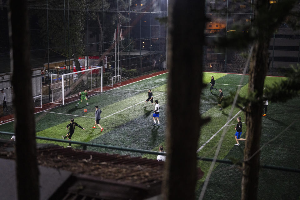 Amateur goalkeeper Mustafa Mert Olcer, left, in action during in a recreational soccer "Astroturf" match in Istanbul, Turkey, Tuesday, March 5, 2024. More than a few times a week, the 18-year-old courier and passionate goalkeeper Mustafa Mert Olcer, gets a call from Rent-a-Goalkeeper to man a goalpost. (AP Photo/Francisco Seco)