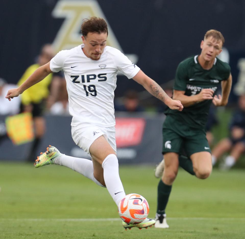 University of Akron's Dyson Clapier drives the ball against Michigan State University player in their men's soccer match in Akron on Monday. The Zips beat the Spartans 2-1.