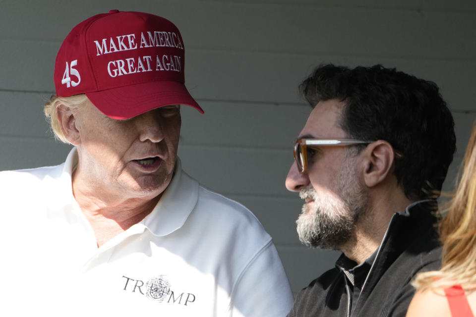 Former President Donald Trump talks with Yasir Al-Rumayyan, during the first round of the LIV Golf Tournament at Trump National Golf Club, Friday, May 26, 2023, in Sterling, Va. (AP Photo/Alex Brandon)