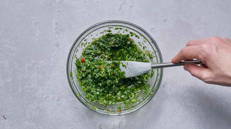 stirring chimichurri in bowl