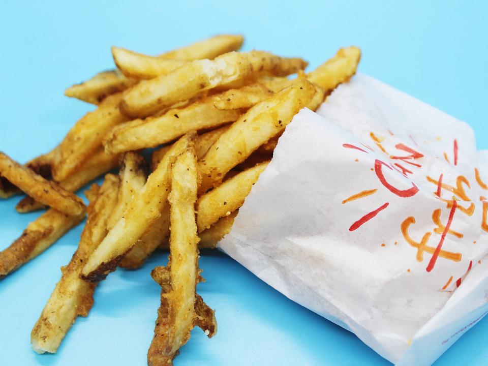 popeyes cajun fries spilling out of white paper bag