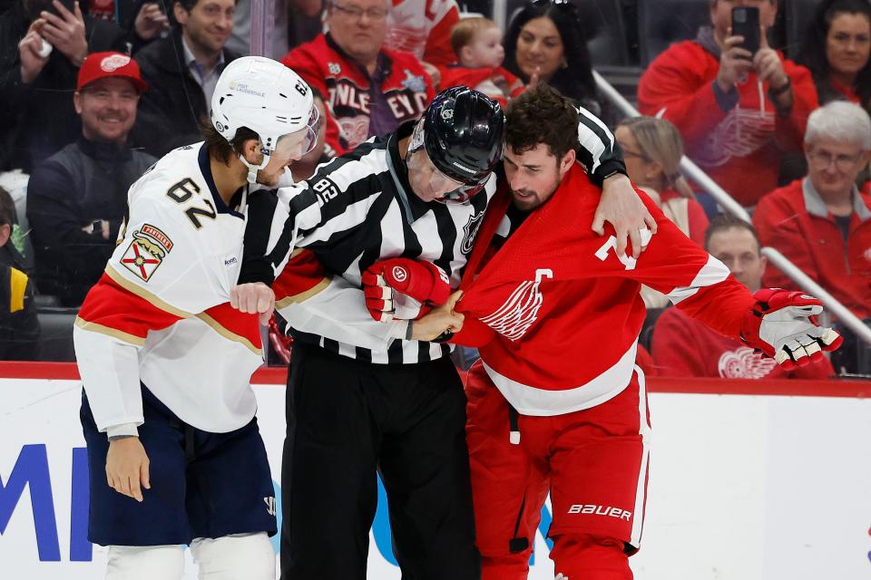 Linesman Ryan Galloway gets between Detroit Red Wings center Dylan Larkin and Florida Panthers defenseman Brandon Montour in the third period at Little Caesars Arena on Saturday, March 2, 2024, in Detroit, Michigan.