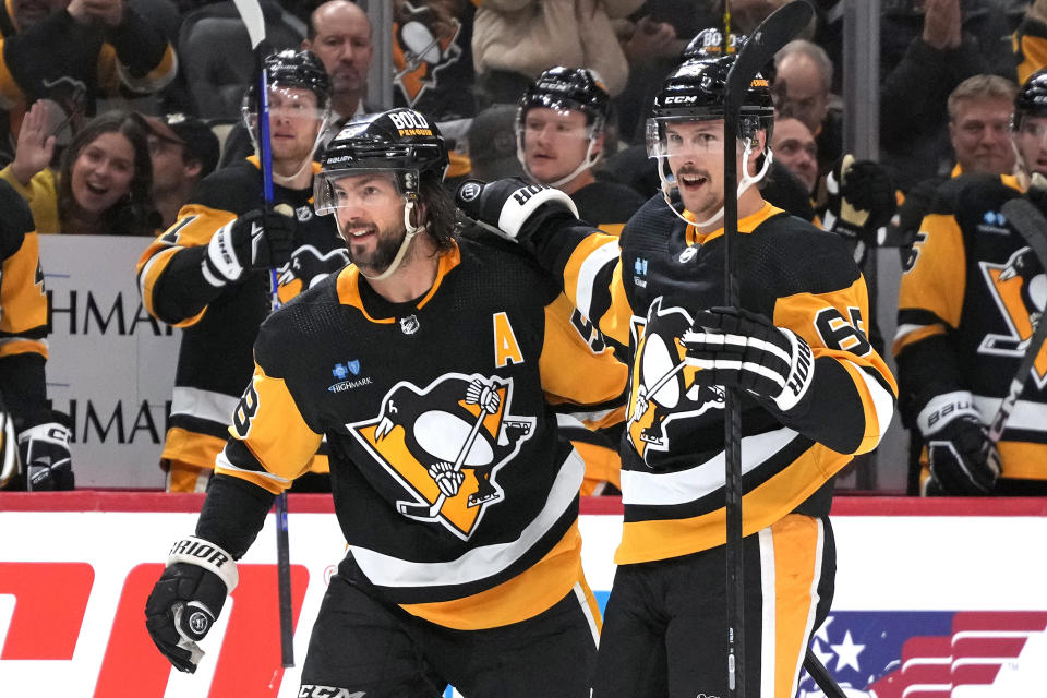 Pittsburgh Penguins' Erik Karlsson (65) celebrates with Kris Letang (58) after scoring during the the second period of an NHL hockey game against the Toronto Maple Leafs in Pittsburgh, Saturday, Nov. 25, 2023. (AP Photo/Gene J. Puskar)