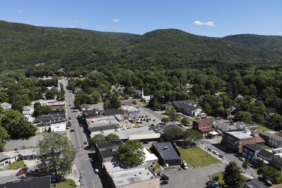 FILE - In this June 16 2021 file photo, Surrounded by trees and mountains, the town of Ellenville, N.Y. is seen in Ulster County. Though pretty, there are pockets of poverty. The county is working with the Center for Guaranteed Income Research at the University of Pennsylvania on a pilot program funded by private donations. One hundred households making less than $46,900 a year in May began receiving a $500 payment each month for a year. Recipients of the money can spend it as they wish, but will be asked to participate in periodic surveys about their physical health, mental health and employment status. (AP Photo/Seth Wenig File)