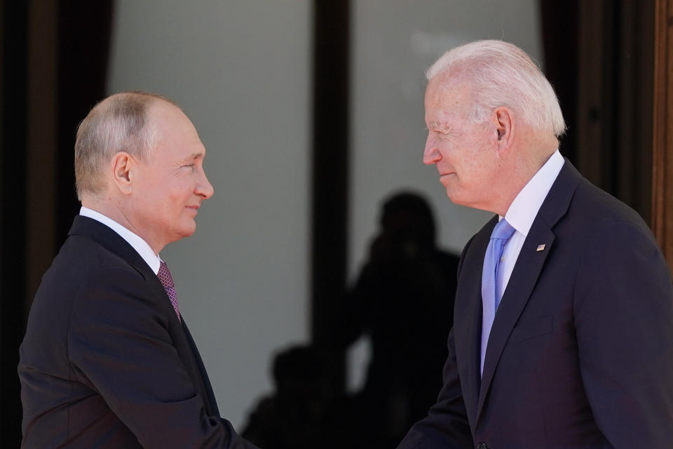 President Biden and Russian President Vladimir Putin shake hands.