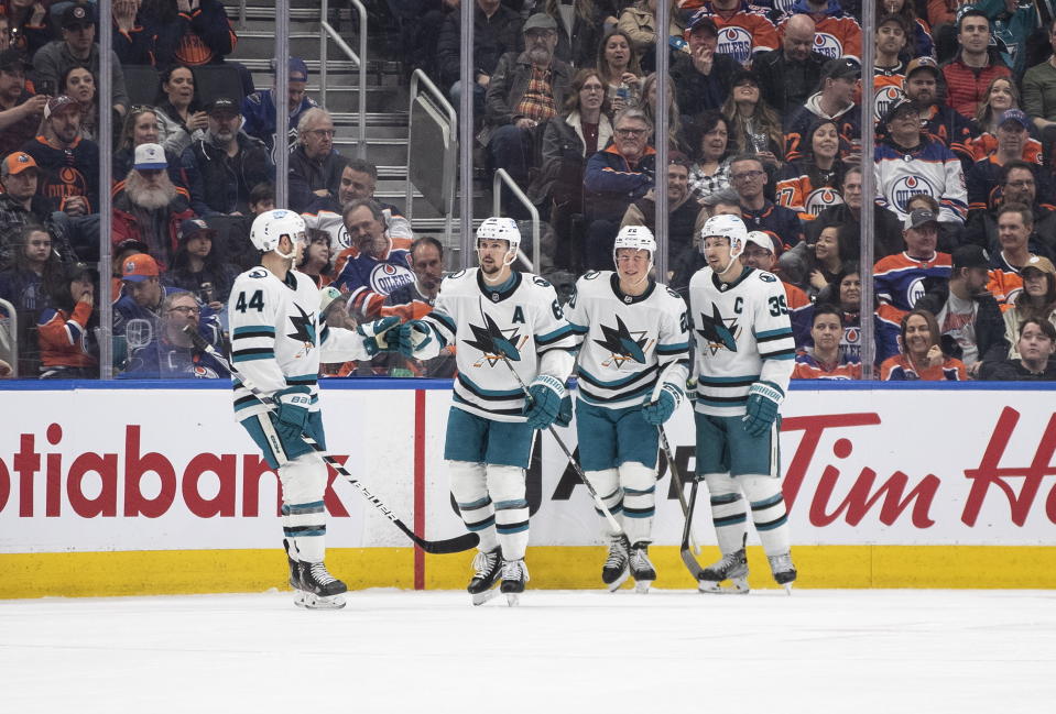 San Jose Sharks' Marc-Edouard Vlasic (44), Erik Karlsson (65), Fabian Zetterlund (20) and Logan Couture (39) celebrate after a goal against the Edmonton Oilers during second-period NHL hockey game action in Edmonton, Alberta, Monday, March 20, 2023. (Jason Franson/The Canadian Press via AP)
