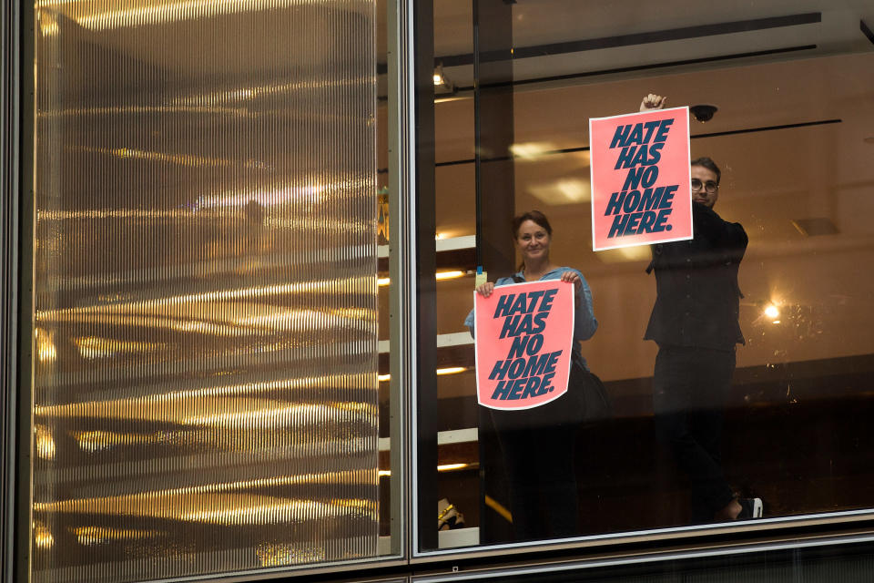 Supporters of anti-Trump protestors hold up signs inside Trump Tower ahead of President Donald Trump's arrival, August 14, 2017 in New York City.&nbsp;