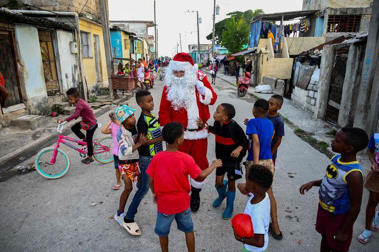 Un hombre vestido de Papá Noel camina con niños por las calles de La Habana el 21 de diciembre de 2023