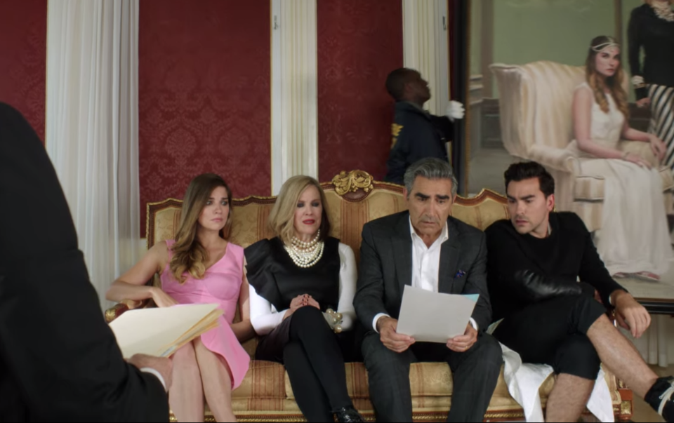 The Rose family sitting on a couch in "Schitt's Creek"