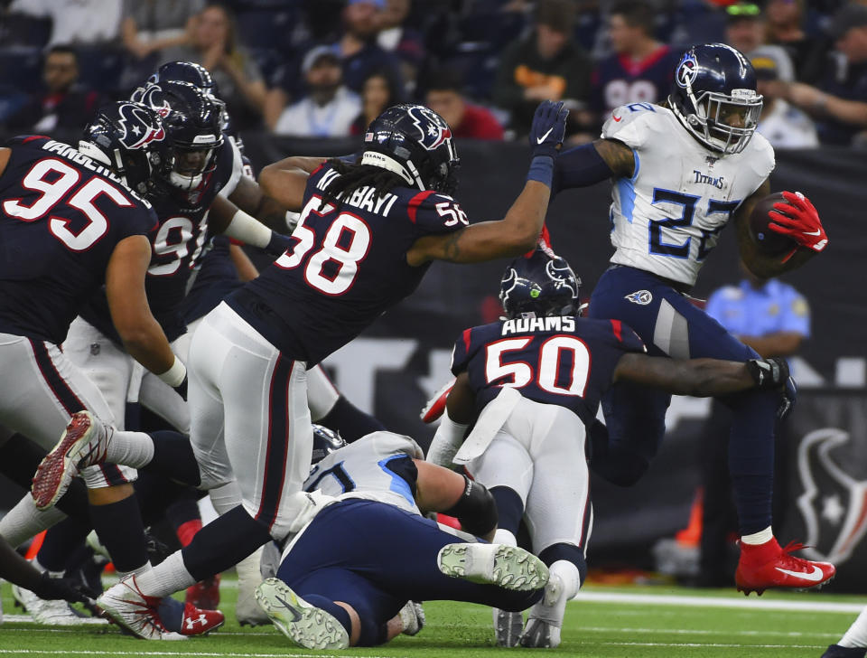 Tennessee Titans running back Derrick Henry (22) rushes for a gain as Houston Texans linebacker Tyrell Adams (50) reaches to tackle him during the second half of an NFL football game Sunday, Dec. 29, 2019, in Houston. (AP Photo/Eric Christian Smith)