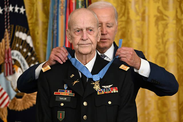 <p>JIM WATSON/AFP via Getty</p> President Joe Biden presents former US Army Captain Larry Taylor with the Medal of Honor