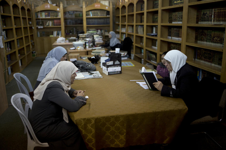 In this photo taken on Monday, Jan. 27, 2014, Palestinian women read at the al-Aqsa mosque compound library in Jerusalem. The library has a collection of some 4,000 old manuscripts with about a quarter considered in poor condition. Half of the books are already undergoing restoration funded by the Waqf, Jordan’s Islamic authority which manages the holy site, and with assistance from UNESCO. (AP Photo/Dusan Vranic)