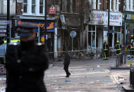 Police survey the aftermath of riots in Clapham Junction Monday night.