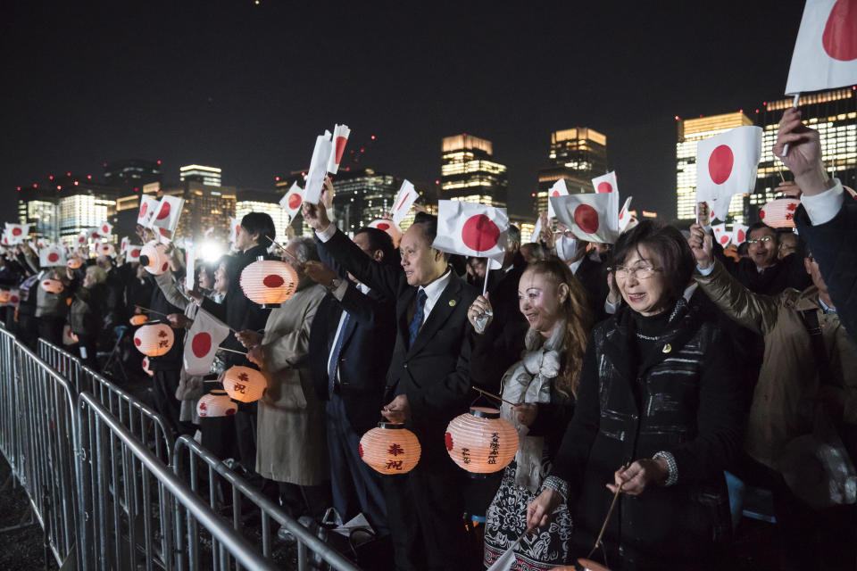 Well-wishers hold Japanese national flags as they cheer during a national festival to celebrate the throne of new emperor at the Imperial Palace in Tokyo Saturday, Nov. 9, 2019. Japanese Emperor Naruhito thanked tens of thousands of well-wishers who gathered outside the palace to congratulate his enthronement at the ceremony organized by conservative political and business groups. (Tomohiro Ohsumi/Pool Photo via AP)