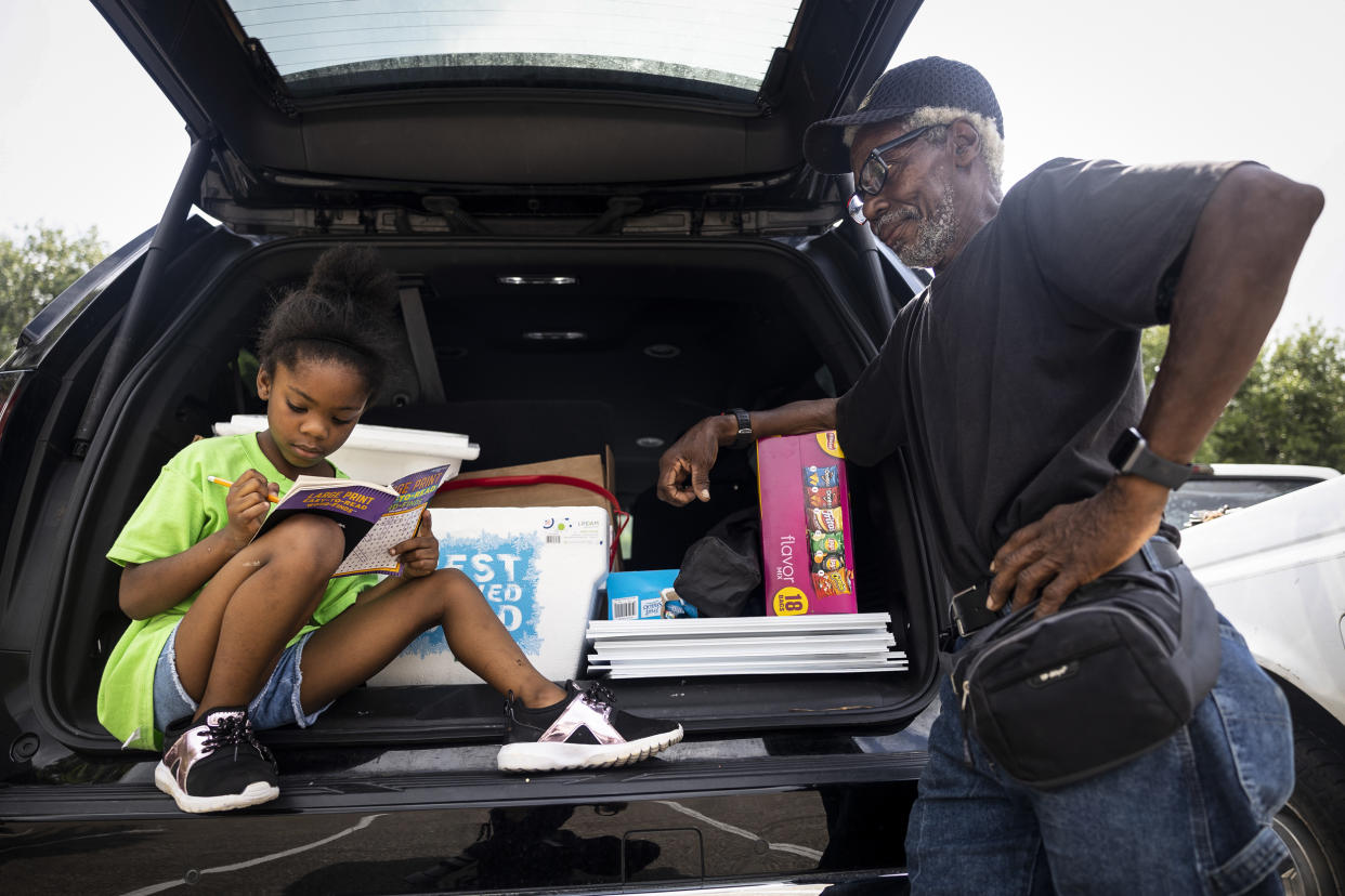 Seven-year-old Olivia Lewis completes crossword puzzles in the back of her mother’s car while her grandfather, Odell Pointer, looks on. Lewis is the daughter of school board trustee hopeful Orjanel Lewis and campaigned with her mother the entire Election Day on May 7, 2022, in Ft. Bend County, Texas. (Annie Mulligan for NBC News)