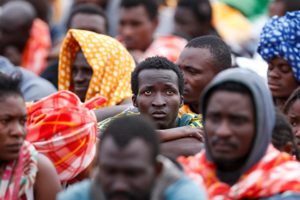 Migrants disembark from a vessel