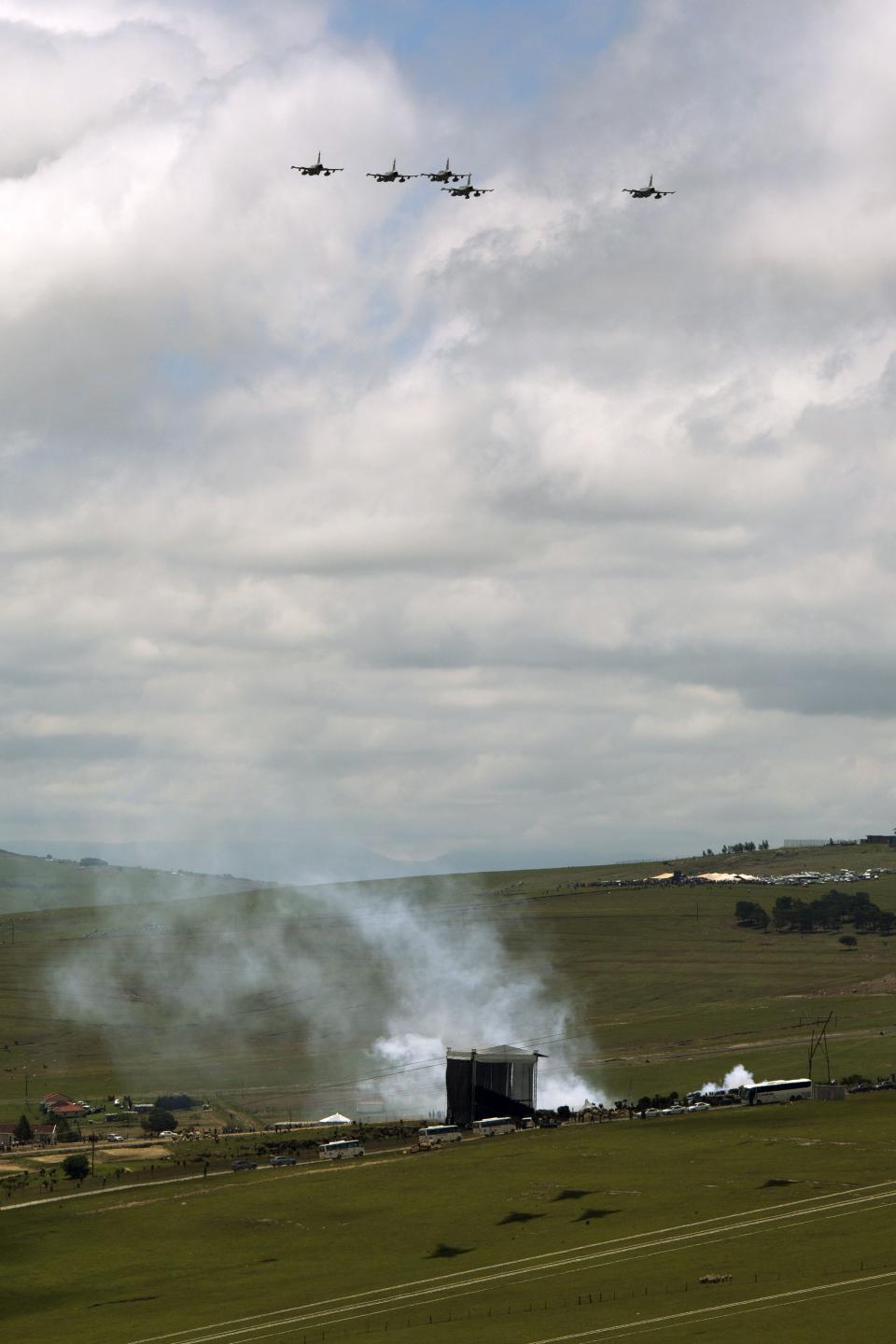 Smoke from cannon fire rises as fighter jets fly in a missing man formation over the burial site of Nelson Mandela in Qunu