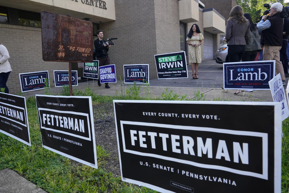 Gisele Barreto Fetterman, rear center, wife of Pennsylvania Lt. Governor John Fetterman, who is running for the Democratic nomination for the U.S. Senate for Pennsylvania, is greeted by a group of reporters as she exits her polling place after voting in Braddock, Pa., Tuesday, May 17, 2022. (AP Photo/Gene J. Puskar)