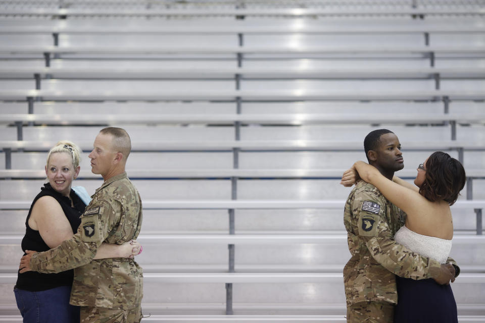 Husband and wife William and Rebecca Prestridge and boyfriend and girlfriend Craig Cooper and Ashley Zeigler embrace following a homecoming ceremony for members of the U.S. Army's 159th Combat Aviation Brigade, 101st Airborne Division at Campbell Army Airfield on Sept. 1, 2014, in Fort Campbell, Kentucky.
