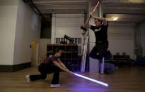 Student Aaron Cheng jumps over a light saber swung by fellow student Starshine Medeiros during a Golden Gate Knights class in San Francisco, Sunday, Feb. 10, 2013. A group of San Francisco Star Wars fans who want to travel to a galaxy not that far away have created a combat choreography class for Jedis-in-training with their weapon of choice: the light saber. (AP Photo/Jeff Chiu)