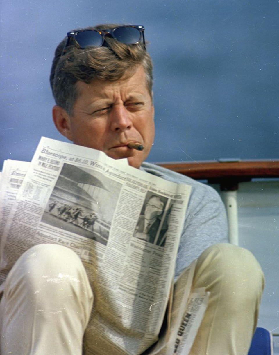 <p>President John F. Kennedy smokes a cigar and reads the newspaper aboard the presidential yacht, the “Honey Fitz,” during Labor Day weekend off the coast of Hyannis Port, Mass., Aug. 31, 1963. (Photo: Cecil Stoughton/White House/John F. Kennedy Presidential Library and Museum) </p>