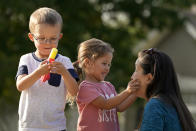 Claire Reagan plays with her kids Evan, 5, and Abbie, 3, Monday, Sept. 21, 2020, outside her home in Olathe, Kan. Reagan is keeping her son from starting kindergarten and her daughter from preschool due to concerns about the coronavirus pandemic. (AP Photo/Charlie Riedel)