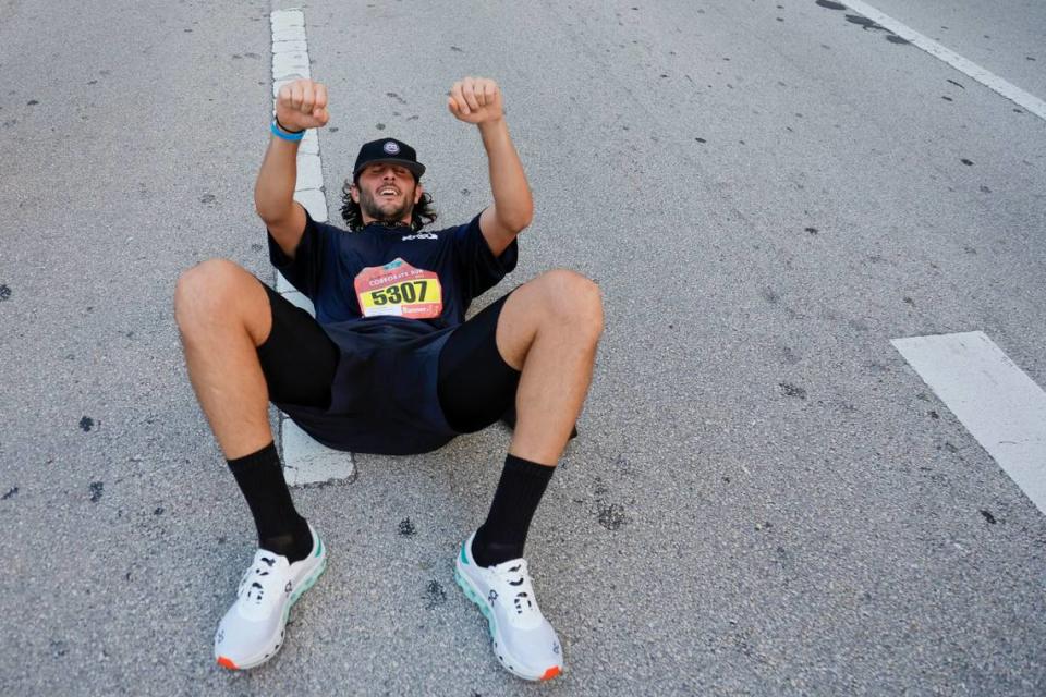 A runner reacts after crossing the finish line during the Miami Lexus Corporate Run in downtown Miami on Thursday, April 27, 2023.