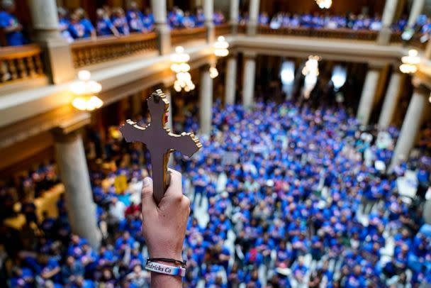 Luke Howard holds a crucifix aloft as anti-abortion supporters rally as the Indiana Senate Rules Committee discusses a Republican proposal to ban nearly all abortions in the state during a hearing at the Statehouse in Indianapolis, July 26, 2022. (Michael Conroy/AP)