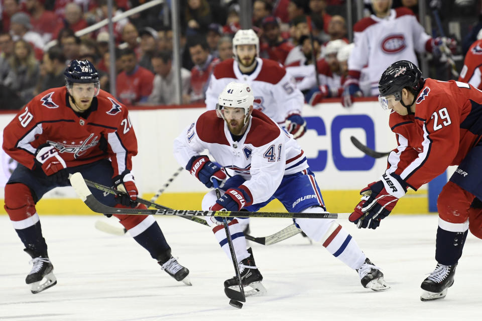 Montreal Canadiens left wing Paul Byron (41) moves the puck between Washington Capitals center Lars Eller (20), of Denmark, and Washington Capitals defenseman Christian Djoos (29), of Sweden, during the first period of their NHL hockey game in Washington, Thursday, April 4, 2019. (AP Photo/Susan Walsh)