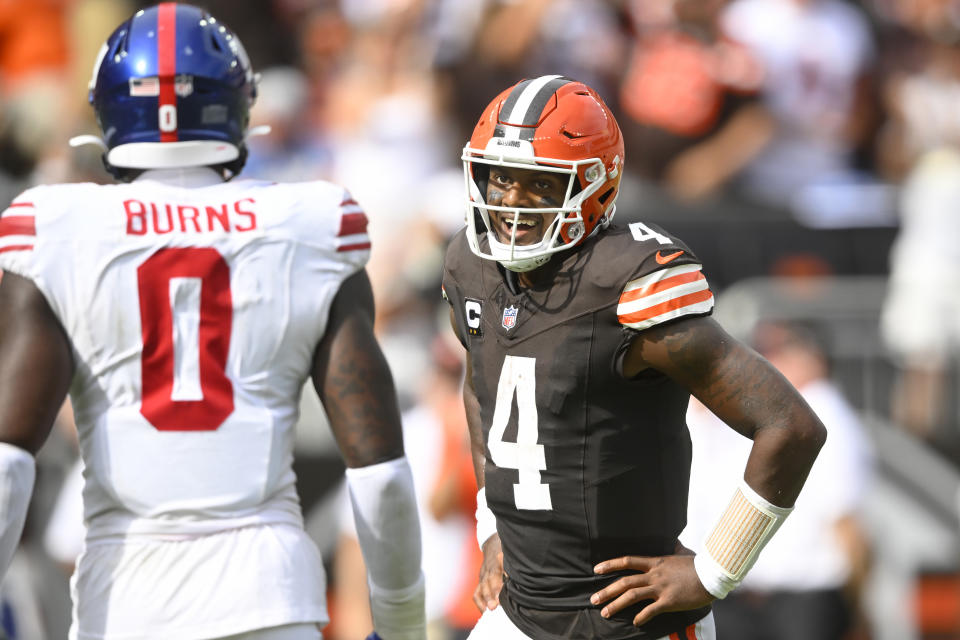 Cleveland Browns quarterback Deshaun Watson (4) reacts after throwing a touchdown pass next to New York Giants linebacker Brian Burns (0) during the second half of an NFL football game, Sunday, Sept. 22, 2024, in Cleveland. (AP Photo/David Richard)