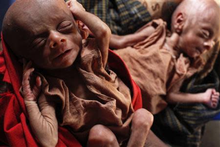 Severely malnourished 25-day-old twins are held by her mother Norbagoun, a displaced Rohingya woman, in their house at the Dar Paing camp for internally displaced people in Sittwe, Rakhine state, April 24, 2014. REUTERS/Minzayar