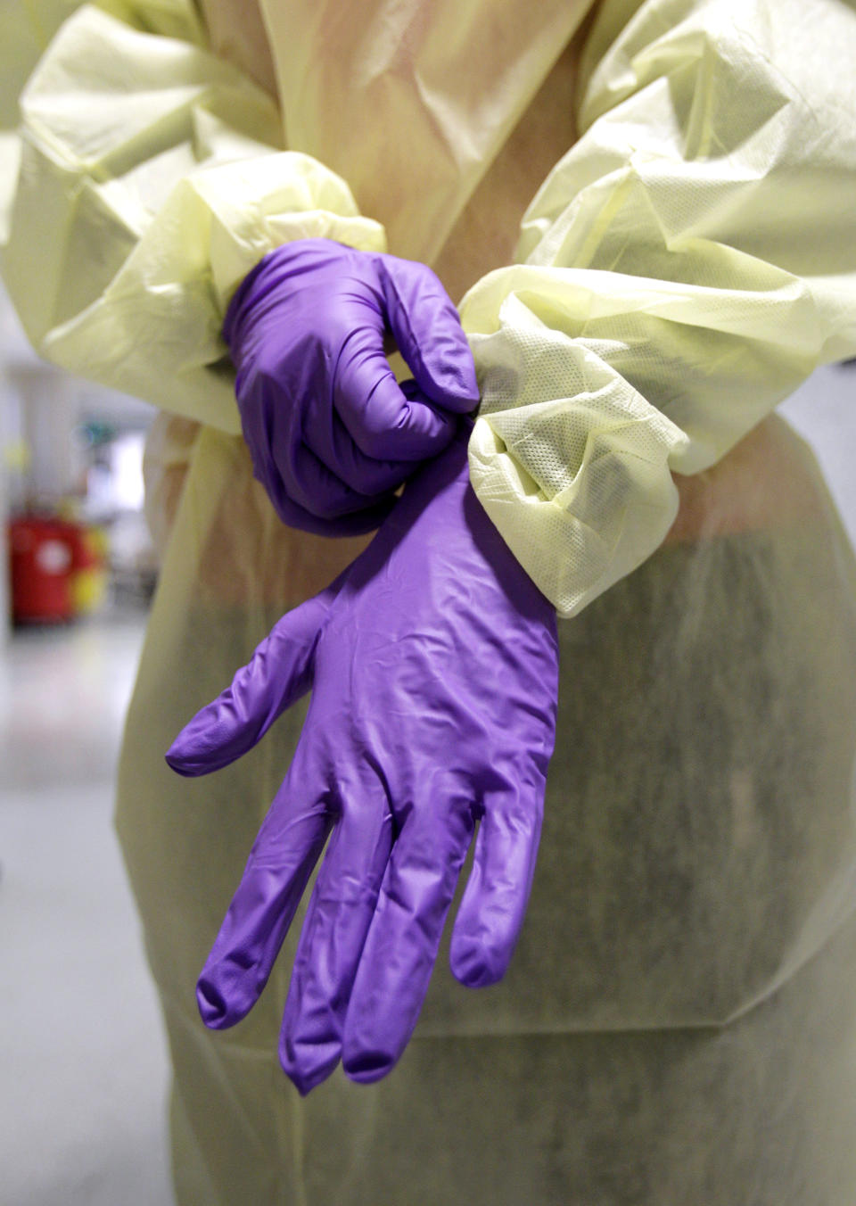 An ICU nurse puts on gloves before entering a patient's room. (Photo: AP Photo/Rob Carr)