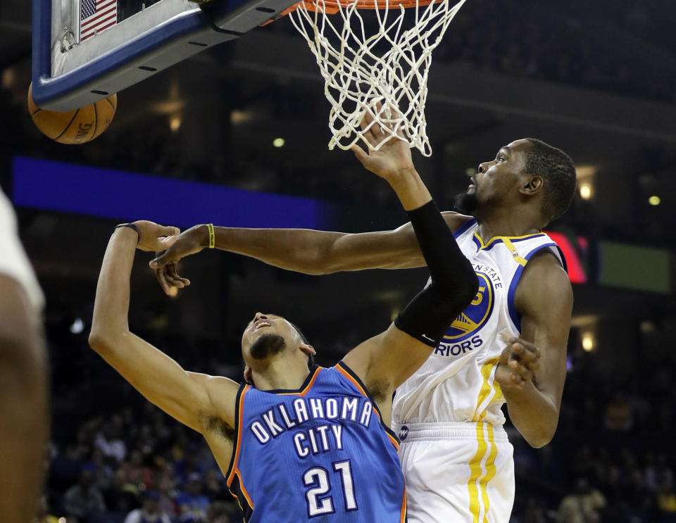 Golden State Warriors' Kevin Durant, right, blocks a shot from Oklahoma City Thunder's Andre Roberson during the first half of an NBA basketball game Wednesday, Jan. 18, 2017, in Oakland, Calif. (AP Photo/Marcio Jose Sanchez)