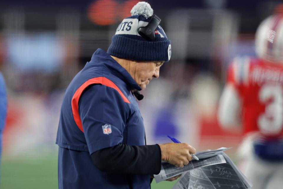 New England Patriots head coach Bill Belichick reviews print outs of previous plays during the first half of an NFL football game against the Buffalo Bills, Thursday, Dec. 1, 2022, in Foxborough, Mass. (AP Photo/Michael Dwyer)