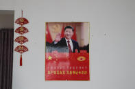 A poster showing an image of Chinese President Xi Jinping is displayed on a wall at a home of members of the Yi minority group in Xujiashan village in Ganluo County, southwest China's Sichuan province on Sept. 10, 2020. Communist Party Xi’s smiling visage looks down from the walls of virtually every home inhabited by members of the Yi minority group in a remote corner of China’s Sichuan province. Xi has replaced former leader Mao Zedong for pride of place in new brick and concrete homes built to replace crumbling traditional structures in Sichuan’s Liangshan Yi Autonomous Prefecture, which his home to about 2 million members of the group. (AP Photo/Andy Wong)