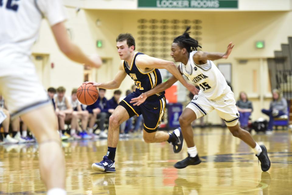 Port Huron Northern's Tyler Jamison dribbles past a defender during the Huskies' 64-54 win over Macomb Dakota at Dakota High School in Macomb on Friday, Feb. 24, 2023.