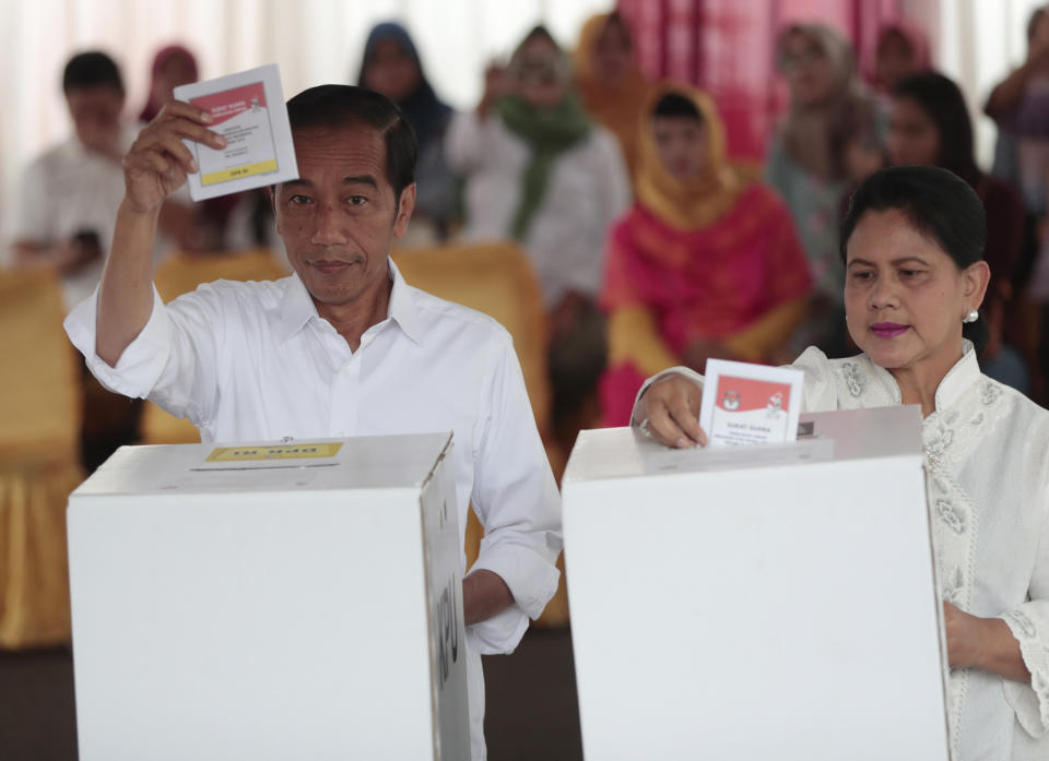 Indonesian President Joko "Jokowi" Widodo and his wife Iriana cast their ballots during the election at a polling station in Jakarta, Indonesia, Wednesday, April 17, 2019. Tens of millions of Indonesians were voting in presidential and legislative elections Wednesday after a campaign that pitted the moderate incumbent against an ultranationalist former general whose fear-based rhetoric warned the country would fall apart without his strongman leadership. (AP Photo/Dita Alangkara)