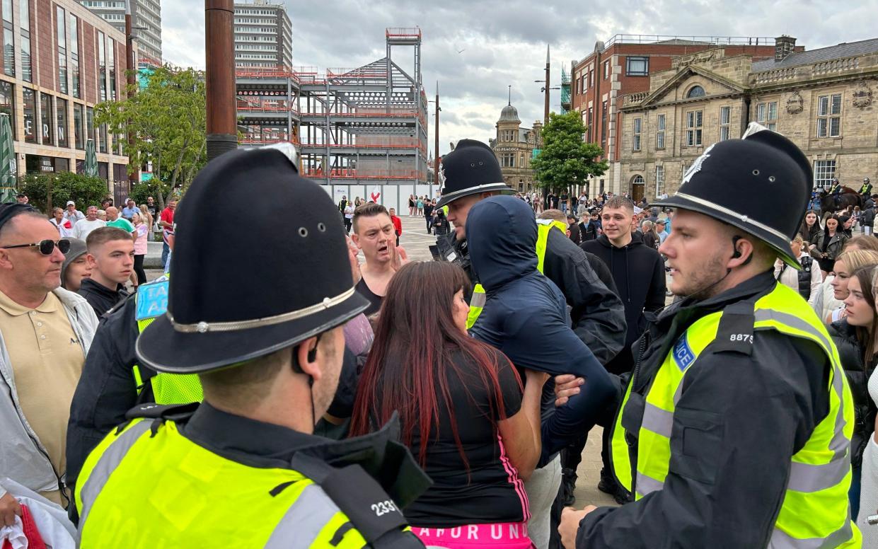 A man wearing a balaclava is arrested by police as security is tightened ahead of a planned protest in Sunderland