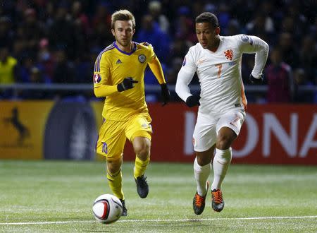 Kazakhstan's Konstantin Engel (L) fights for the ball with Memphis Depay of the Netherlands during their Euro 2016 group A qualifying soccer match at the Astana Arena stadium in Astana, Kazakhstan, October 10, 2015. REUTERS/Shamil Zhumatov