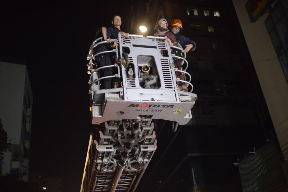 Firefighters rescue a woman from a fire that broke out at a commercial complex in Dhaka, Bangladesh, Thursday, Feb. 29, 2024. Bangladesh's health minister says a fire in a six-story commercial complex in the nation's capital, Dhaka, has killed several people and injured dozens of others. (AP Photo/Mahmud Hossain Opu)