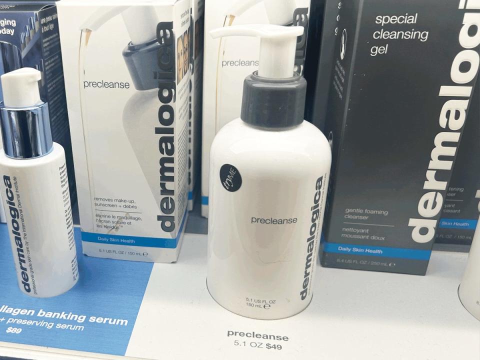 A white bottle with a gray pump of Dermalogica precleanse in front of white and gray Dermalogica boxes at Sephora