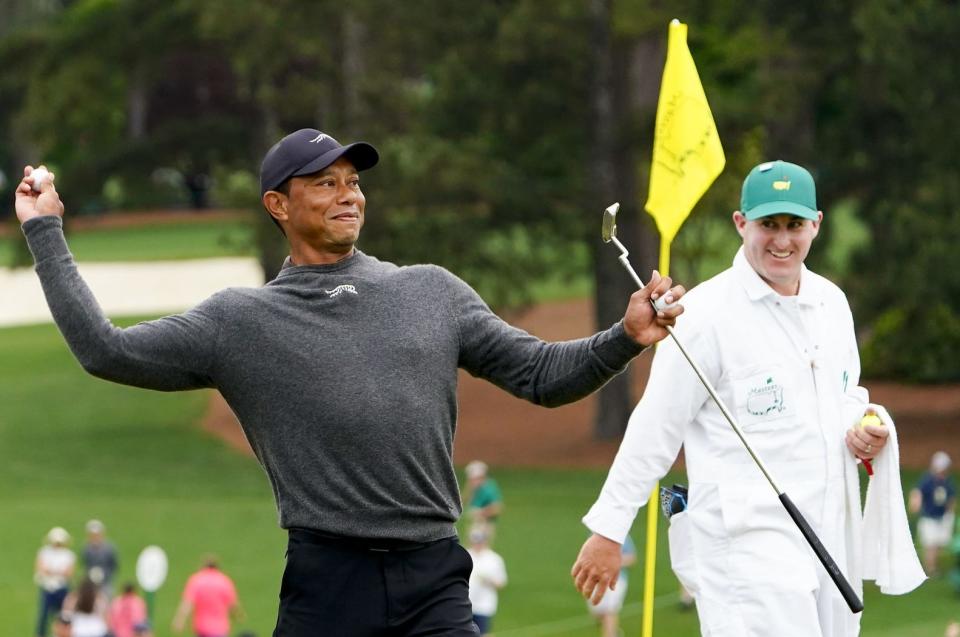 Tiger Woods tosses a ball into the crowd near the ninth green of the Augusta National Golf Club on April 9 during a practice round for the Masters.